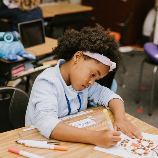 A 3rd grade girl practicing her letters.